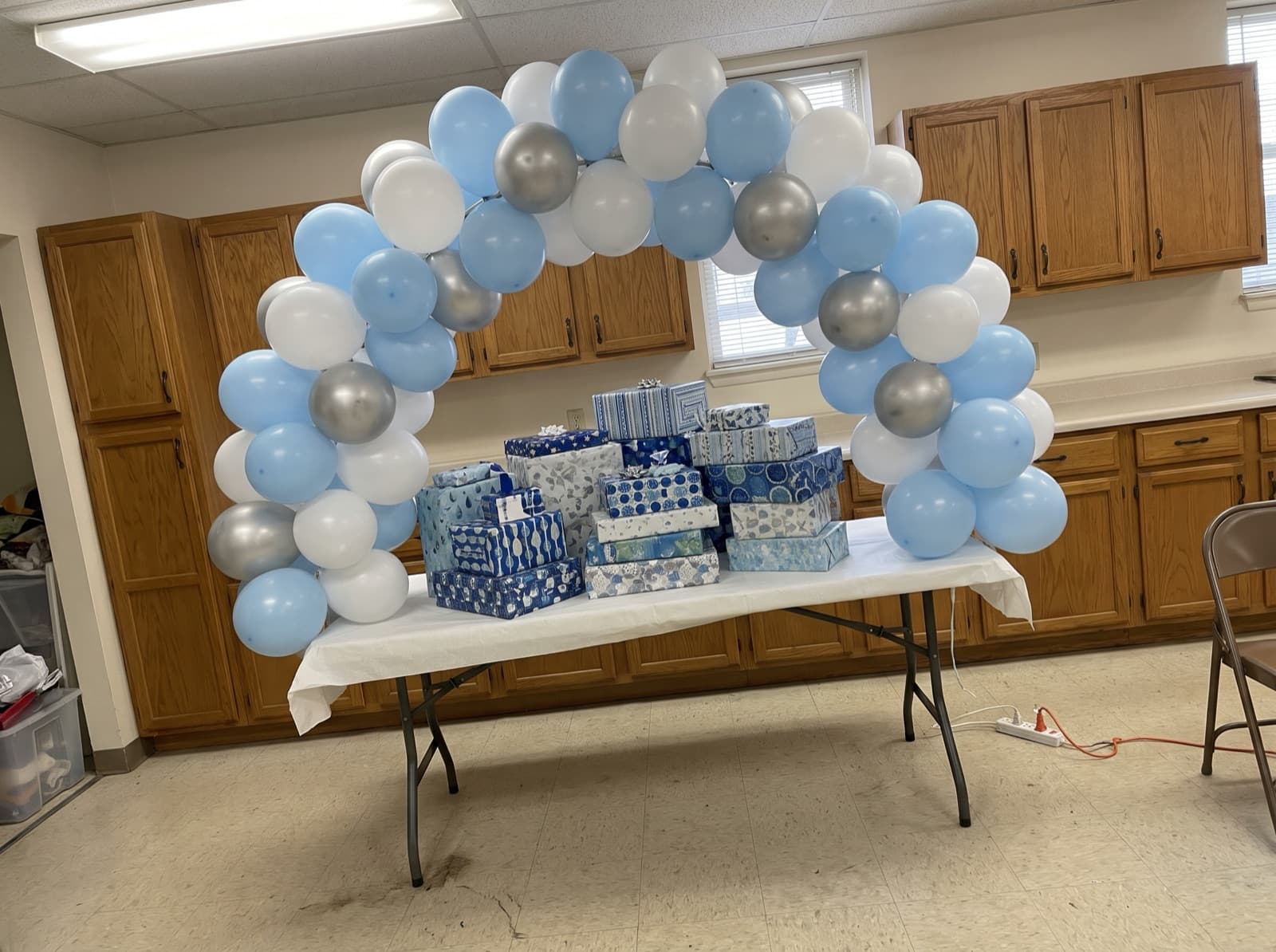 Small tabletop arch in powder blue and silver above a pile of gifts